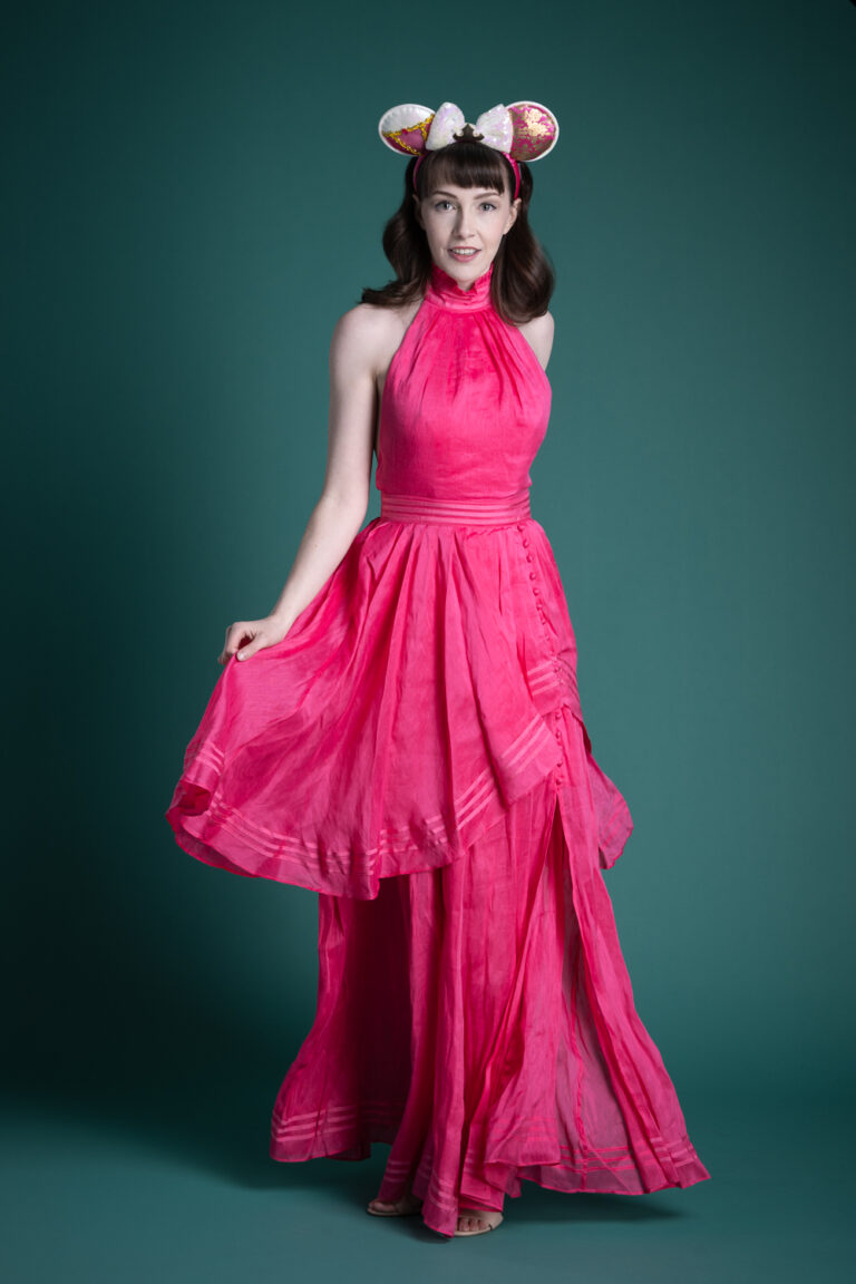 Delanie in a pink dress on a Spruce background